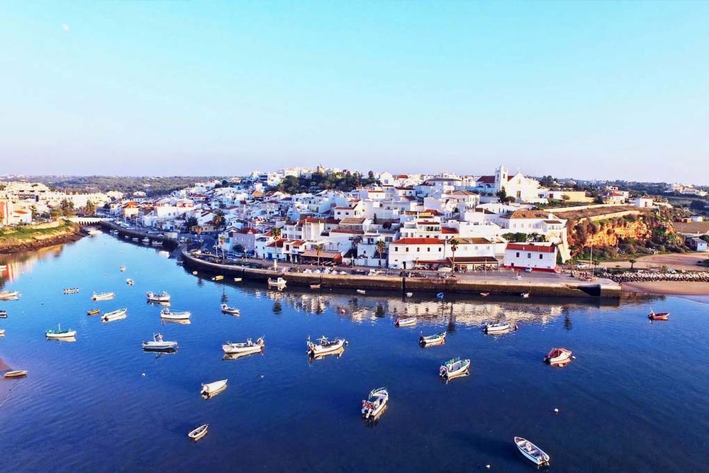 Aerial view of Ferragudo village, boats on river in Carvoeiro.