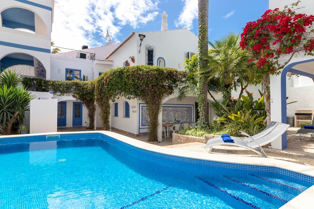 Carvoeiro villa with blue pool, lush gardens, and traditional Portuguese designs.